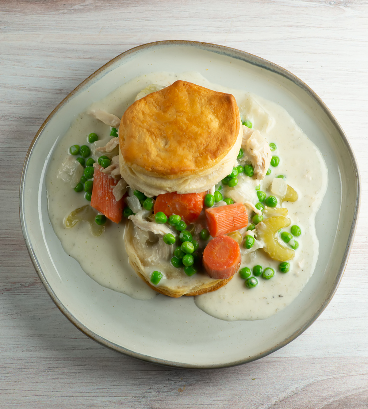 Creamy slow cooker chicken and biscuits on a plate.