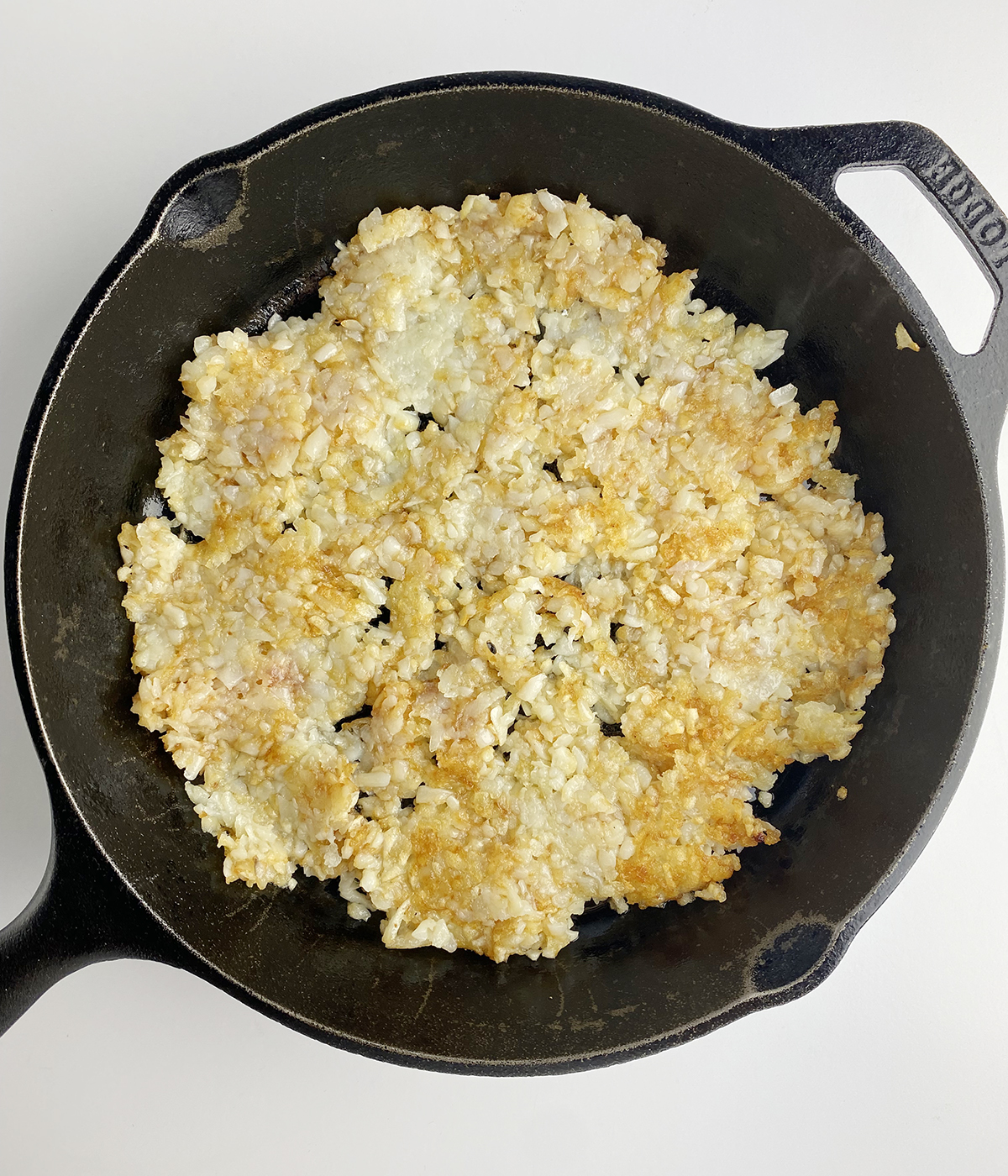 Browned Tater Tot crust in a skillet.