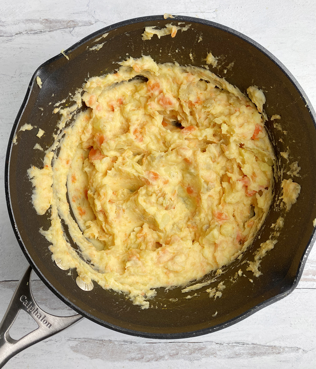 Carrot mashed potatoes in a pot.