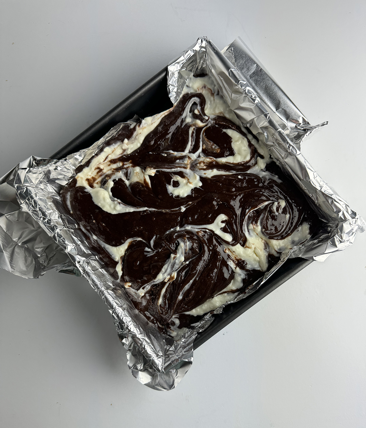 Swirled cheesecake brownie batter ready for the oven.