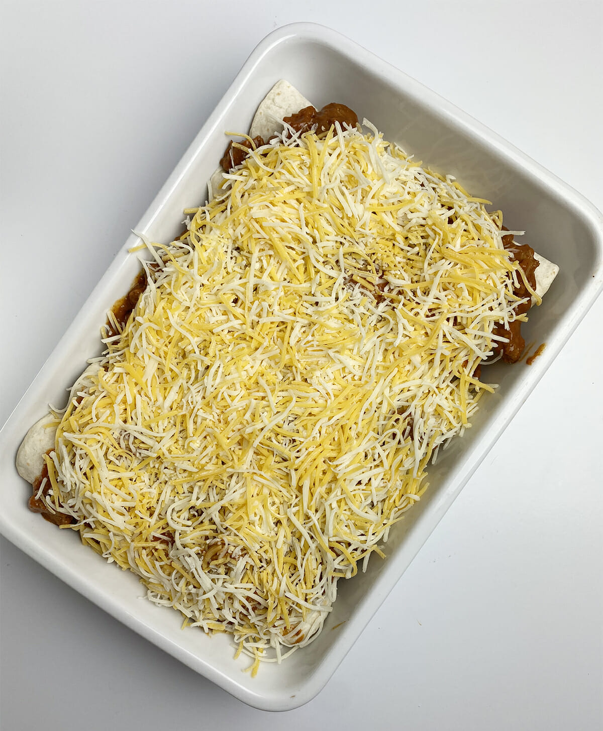 Chili dog casserole with cheese sprinkled on top.
