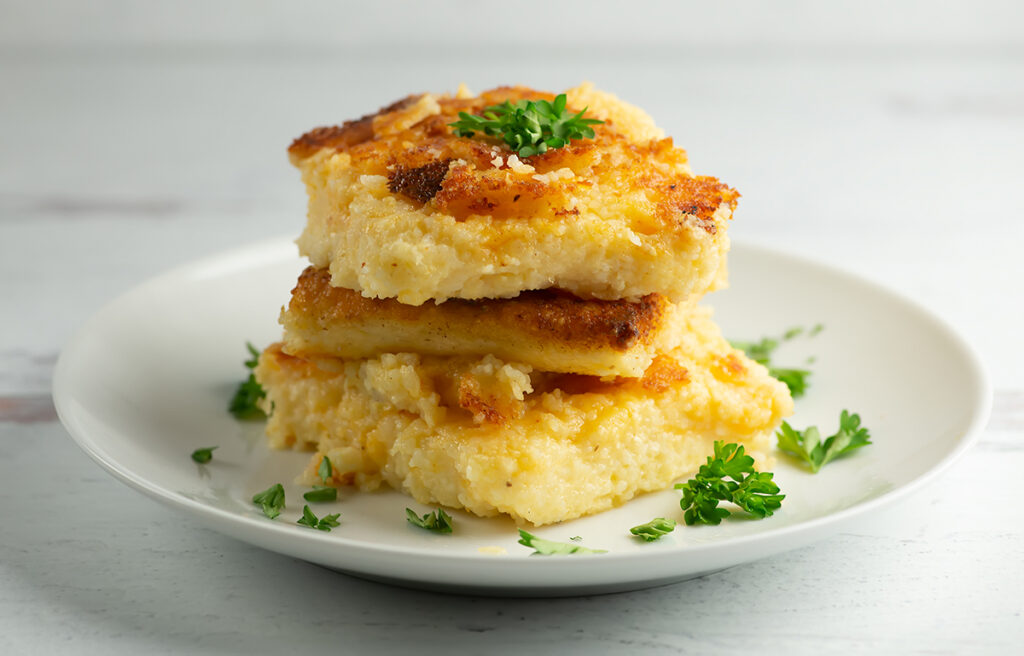 Cheesy Grit Cakes with parsley on plate.
