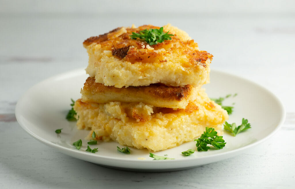 Cheesy Grit Cakes with parsley on plate