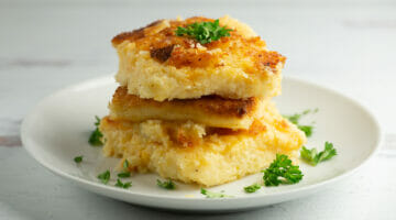 Cheesy Grit Cakes with parsley on plate