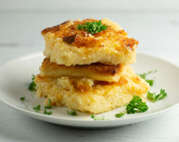 Cheesy Grit Cakes with parsley on plate