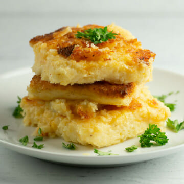 Cheesy Grit Cakes with parsley on plate