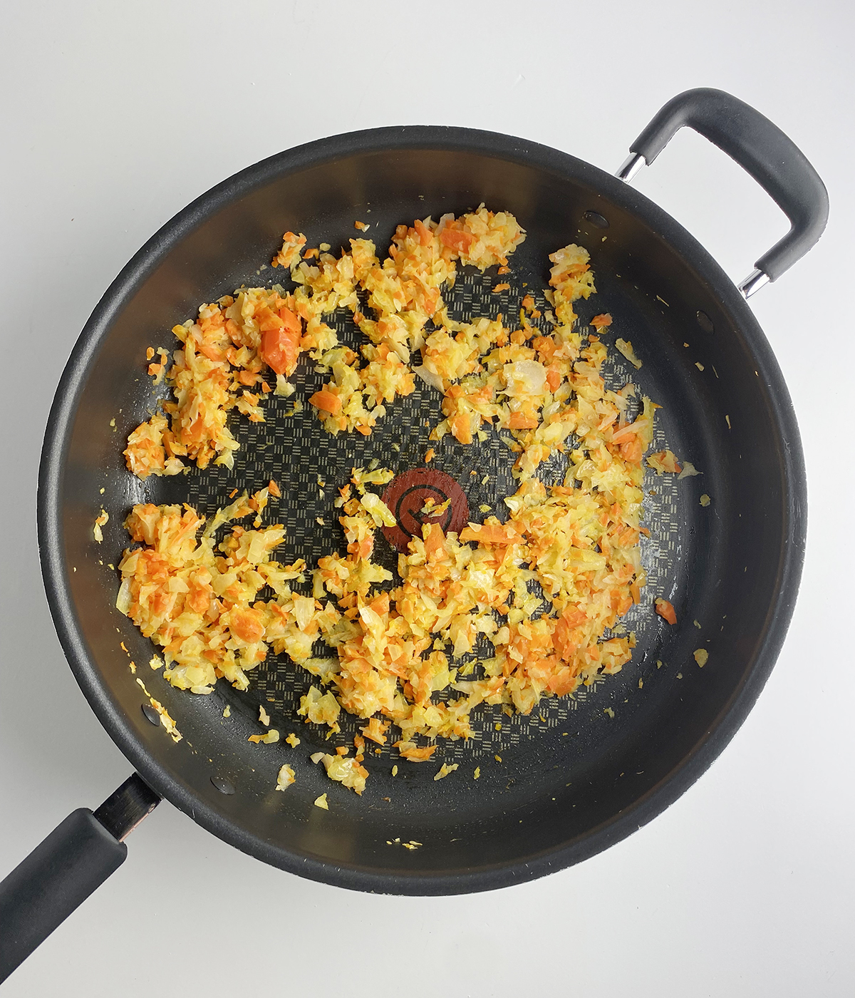 Chopped carrots and onions ina skillet.