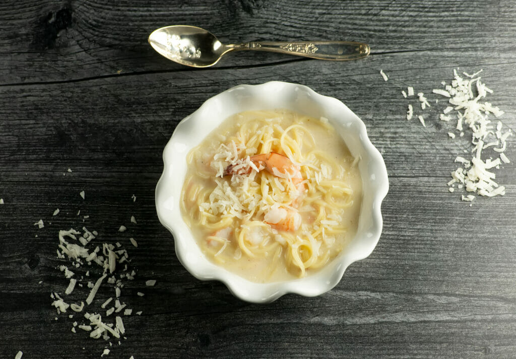 Coconut Shrimp Soup with spoon on grey board