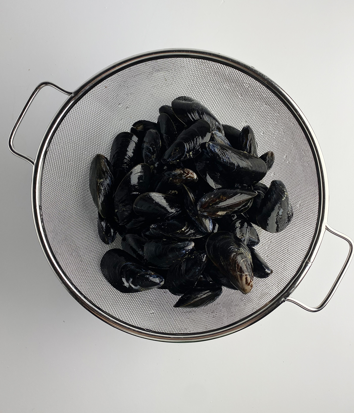 Rinsed mussels in a strainer.