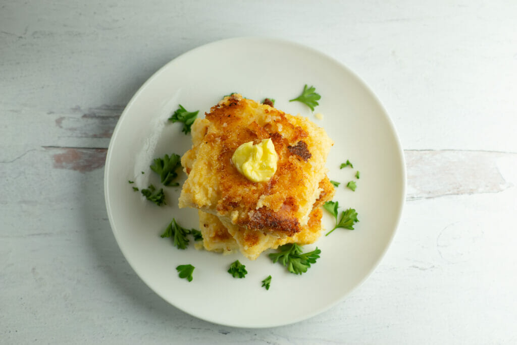 cheesy grit cakes with butter on plate