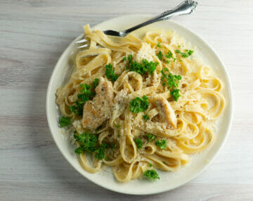 chicken alfredo on plate with fork