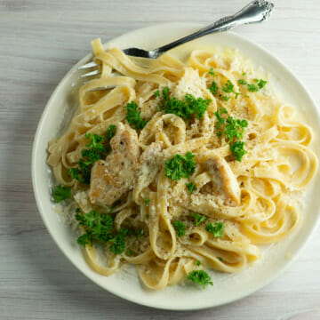 Chicken alfredo on a plate with a fork.