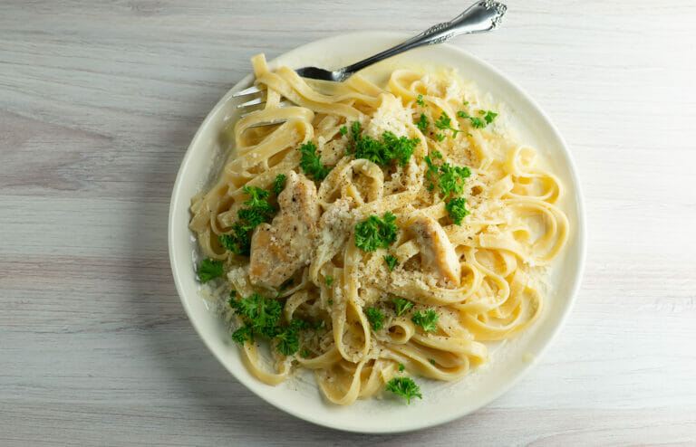 Chicken alfredo on a plate with a fork.