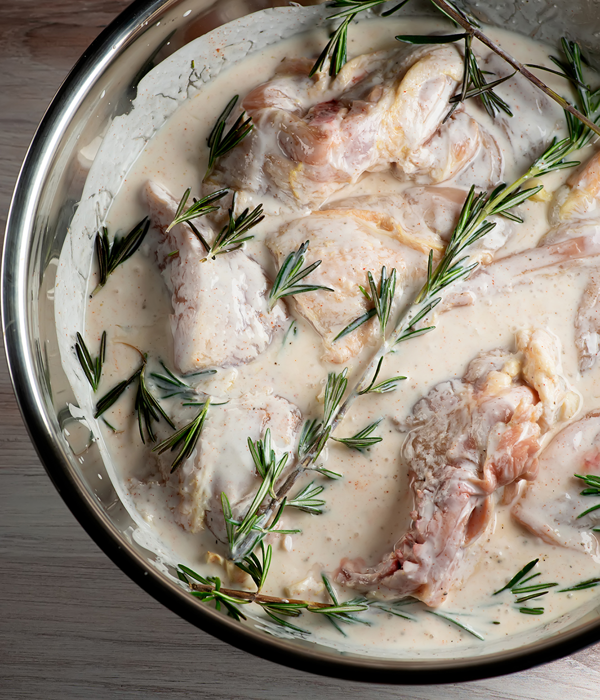 Buttermilk rosemary chicken marinating in a bowl.