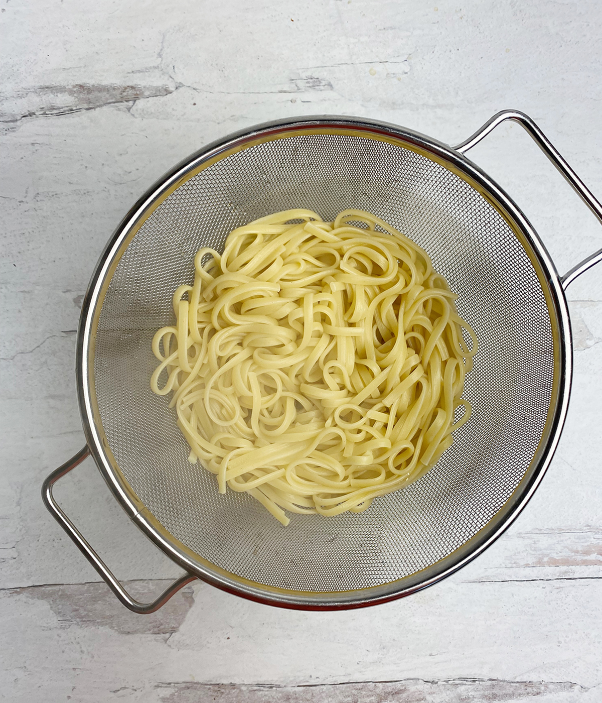 Cooked pasta draining in a colander.