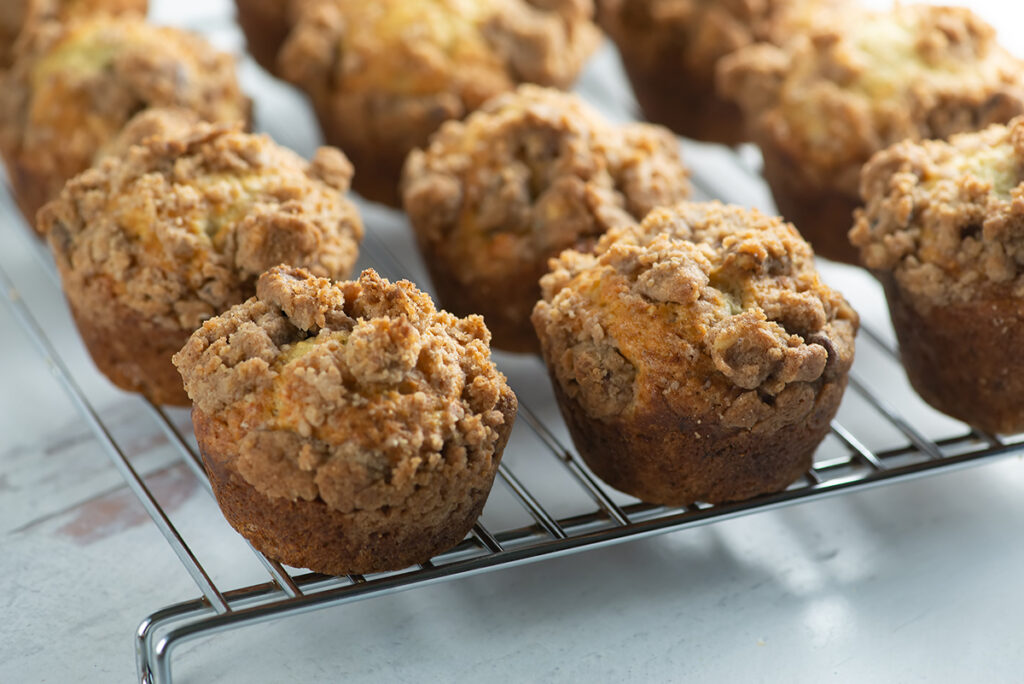 Banana coffee cake muffins on a cooling rack.