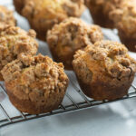 Banana coffee cake muffins on a cooling rack.