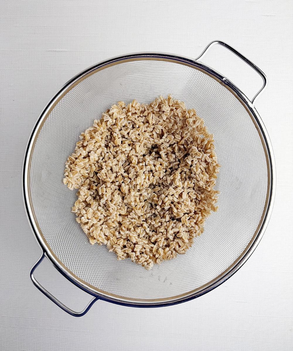 Cooked farro in a strainer.