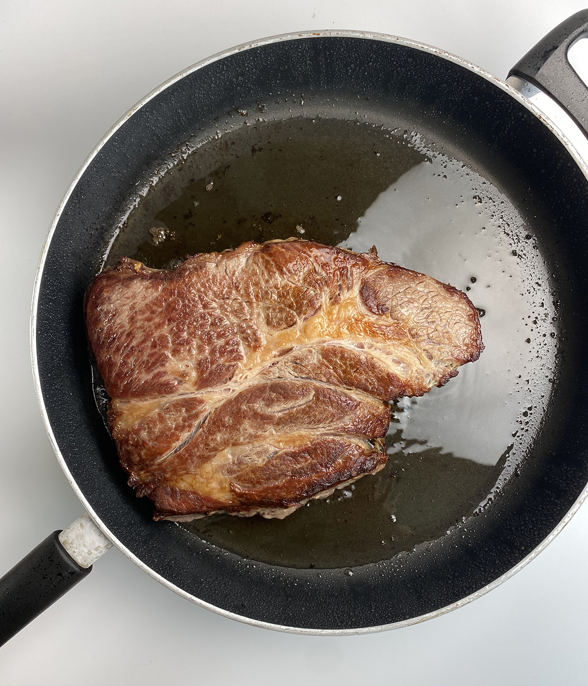 Seared chuck steak in a skillet.