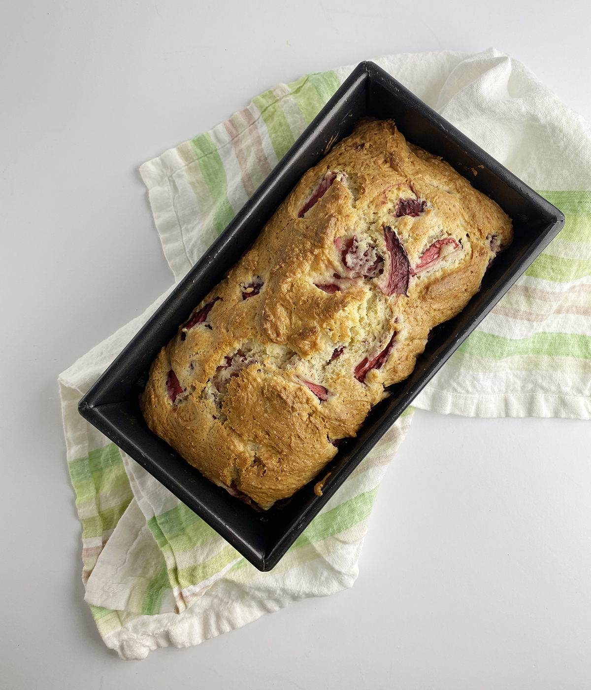 Strawberry bread fresh out of the oven on a dishcloth.
