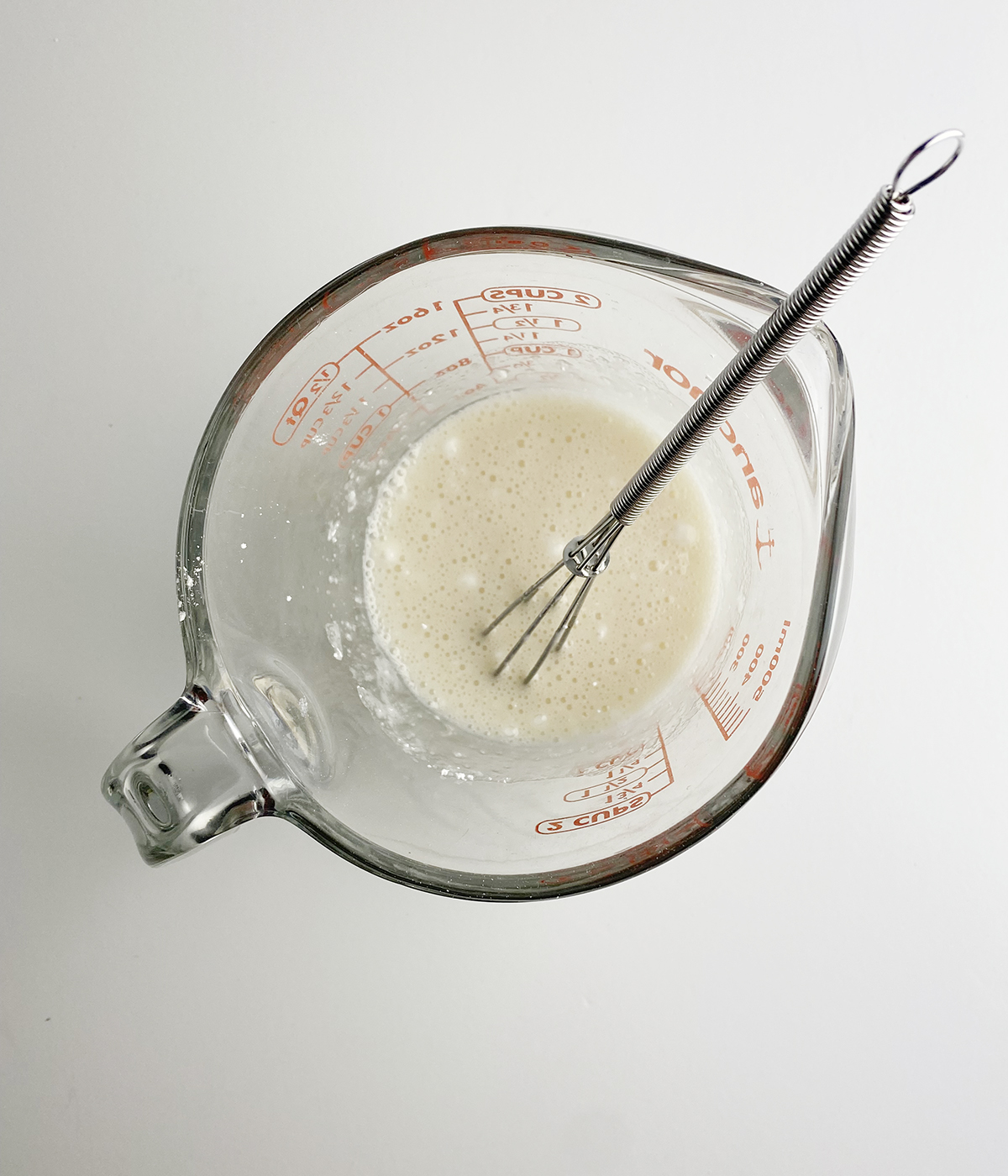 Strawberry glaze mixture in a measuring cup.