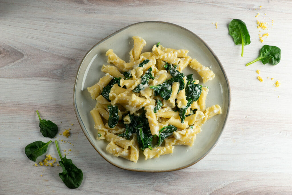 Pasta with lemon ricotta spinach sauce on a plate.