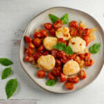 scallops with roasted cherry tomato sauce on plate