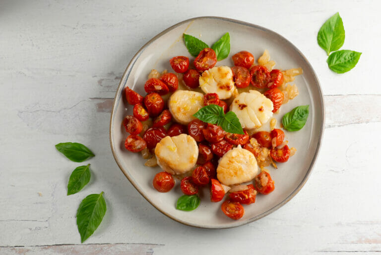 scallops with roasted cherry tomato sauce on plate