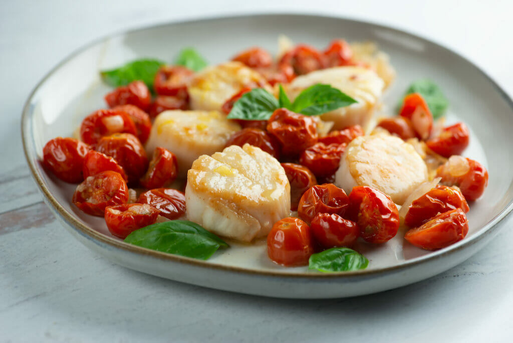 scallops with roasted cherry tomato sauce on plate