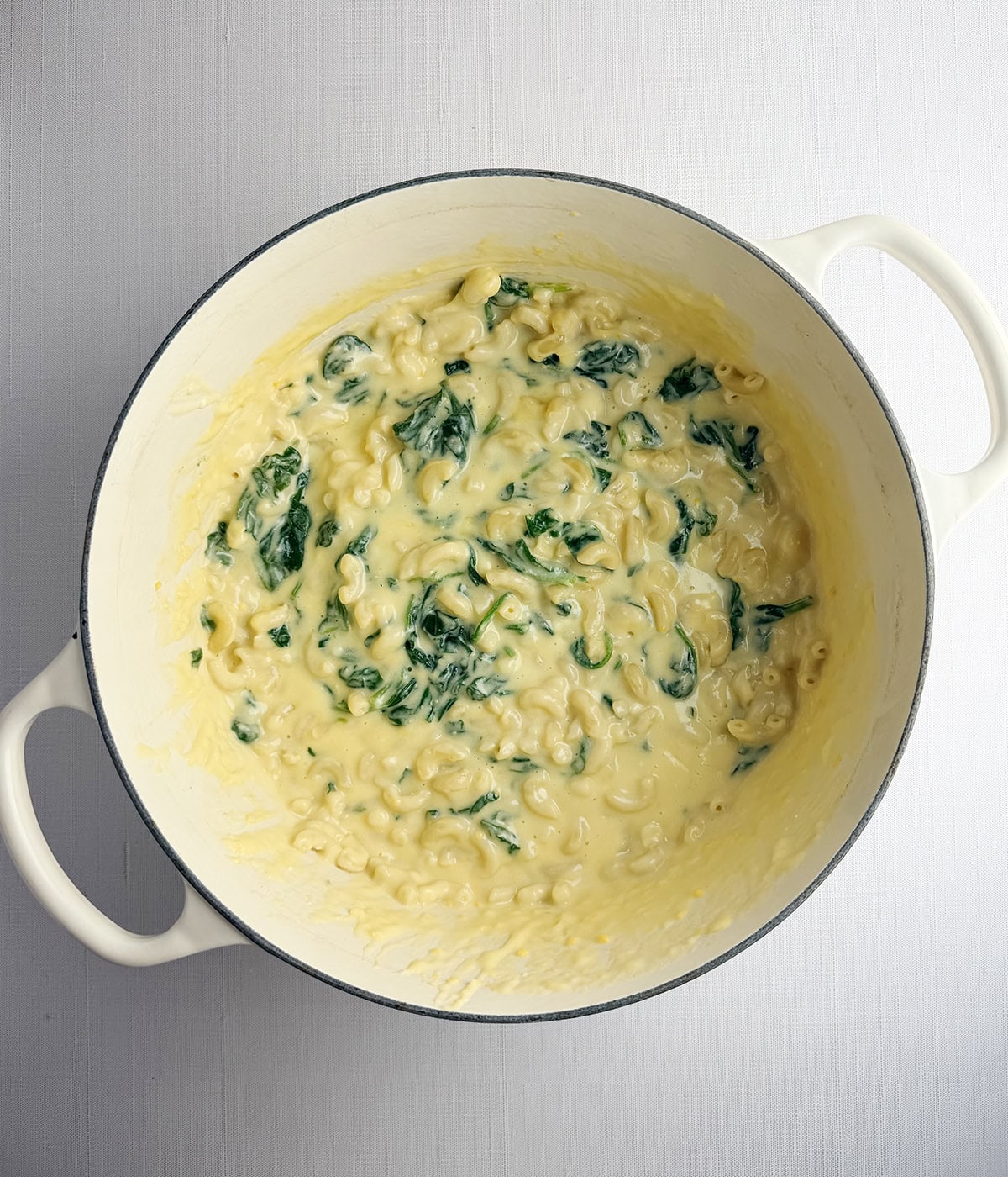 Pot with spinach macaroni and cheese.