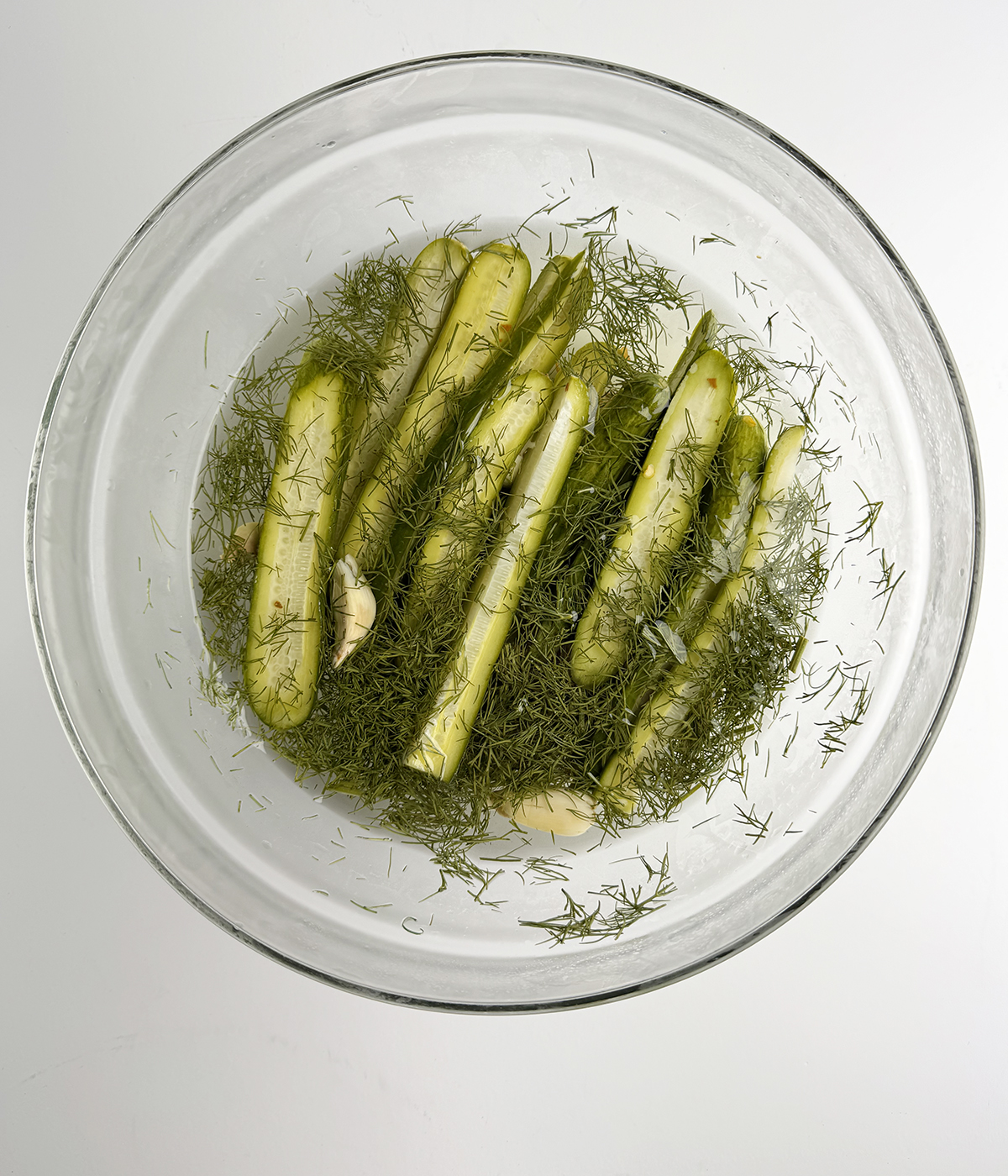Refrigerator pickles marinating in brine.