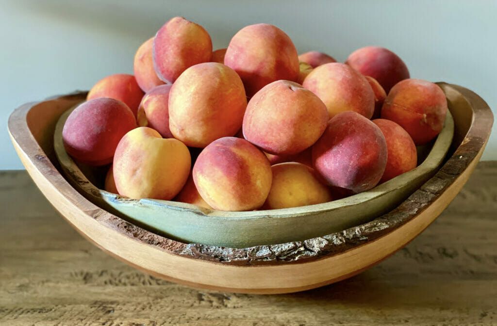 Peaches in a wooden bowl.
