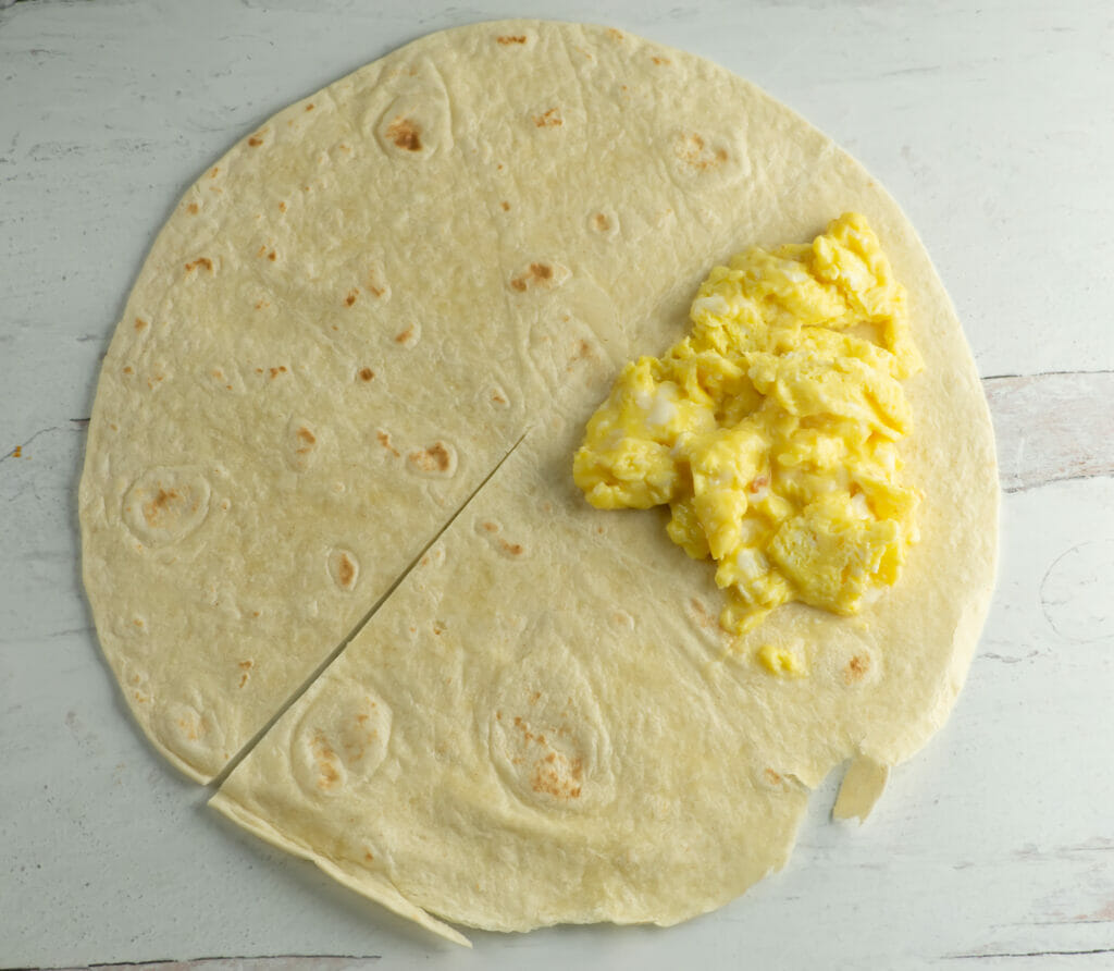 Breakfast quesadilla with eggs on one section.