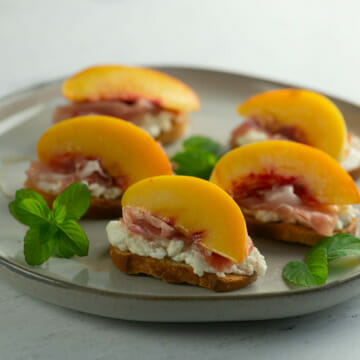 plate of peach crostini with mint