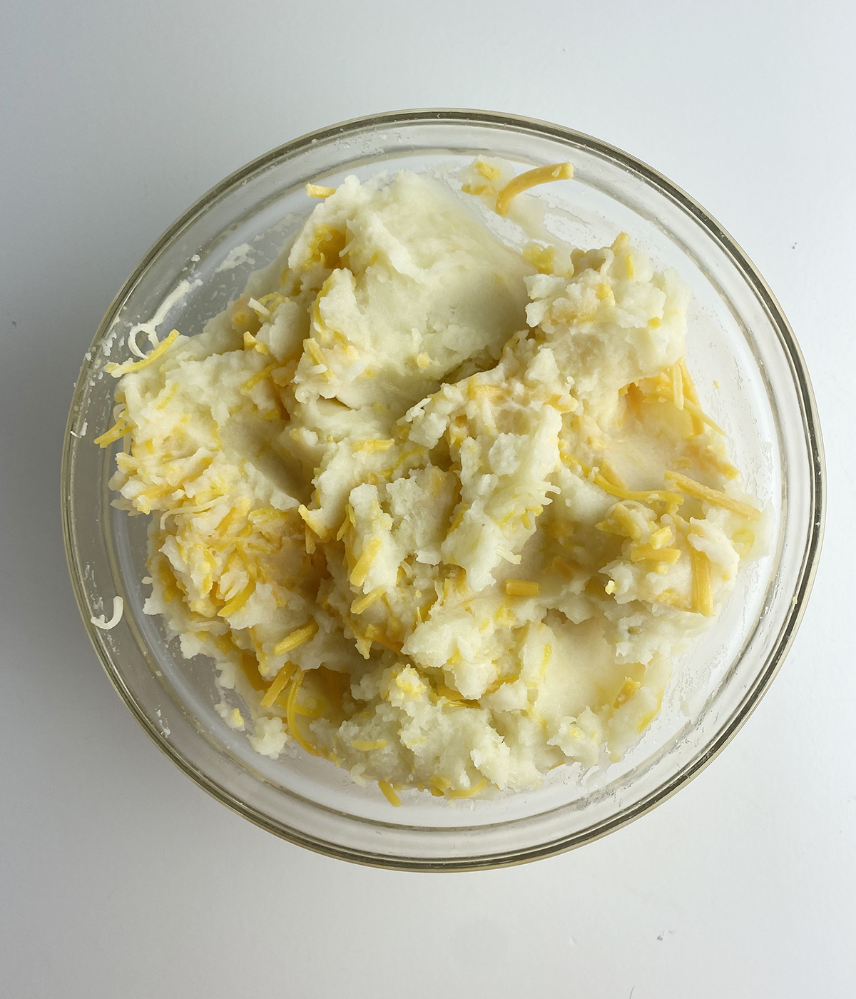 Bowl of mashed potatoes with cheese.