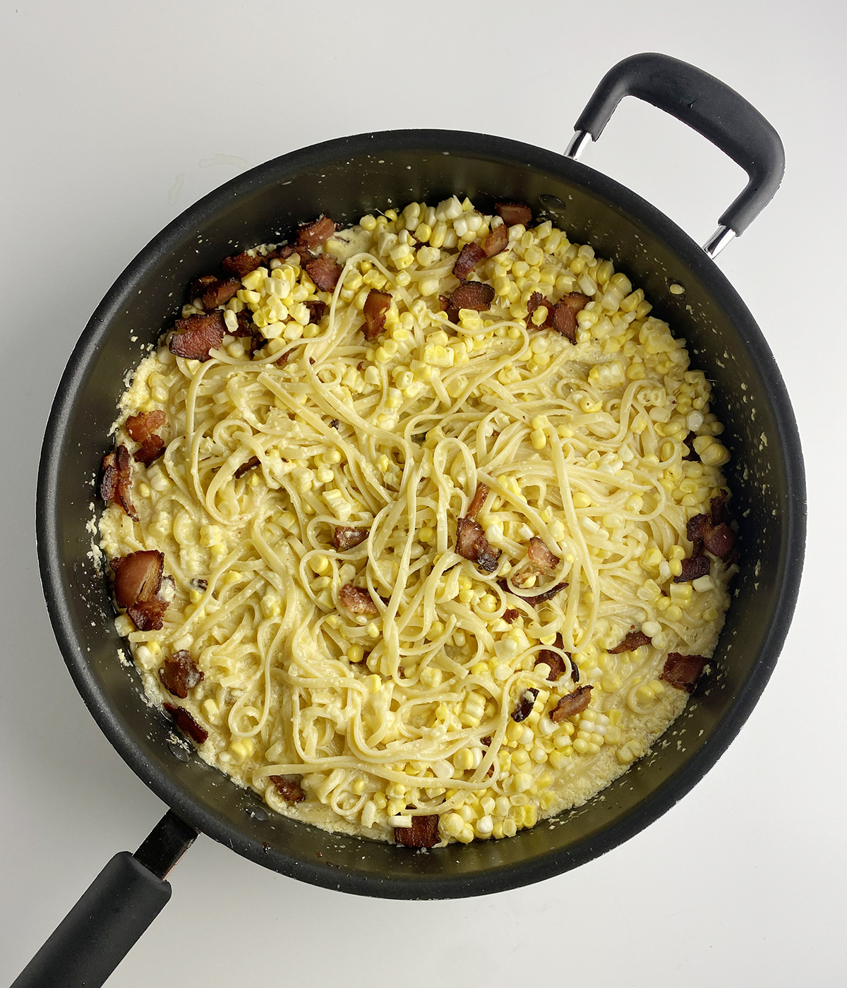 Corn carbonara in a skillet.