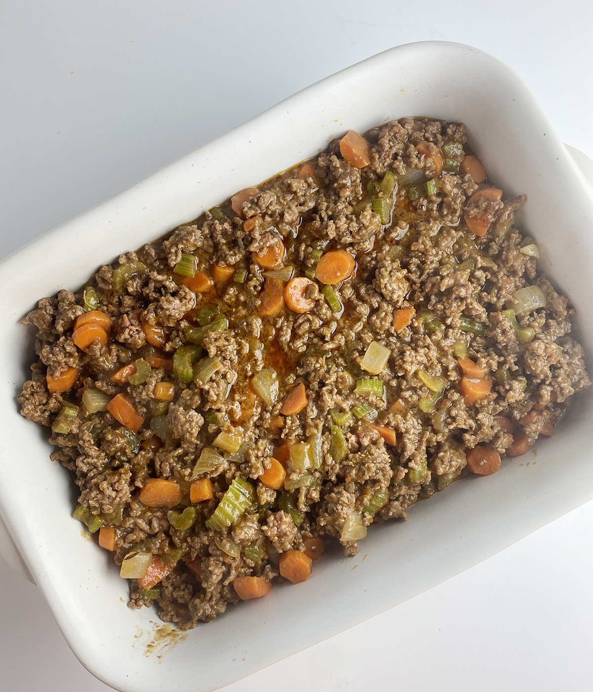 Meat and vegetable layer of cheesy cottage pie.