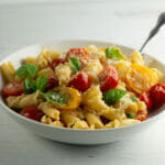 Pasta with fresh tomato and basil sauce in a bowl.