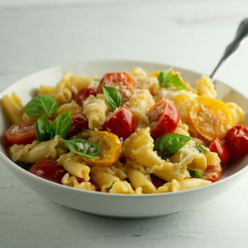 Pasta with fresh tomato and basil sauce in a bowl.
