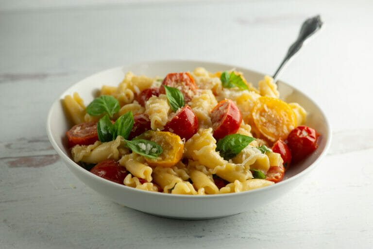 Pasta with fresh tomato and basil sauce in a bowl.