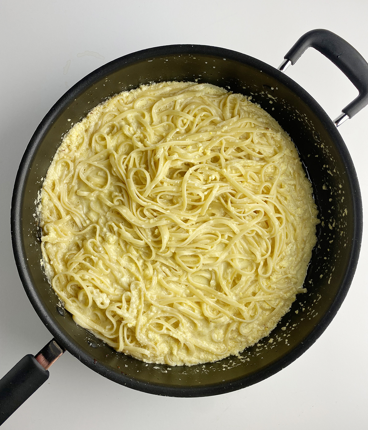 Pasta with eggs in a skillet.