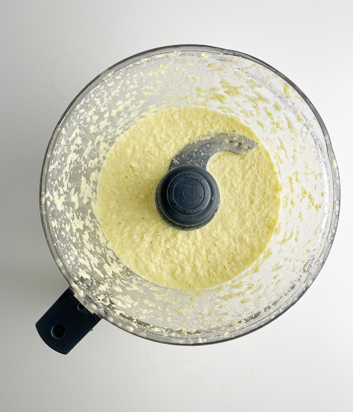 Pureed corn kernels and cream in a food processor.