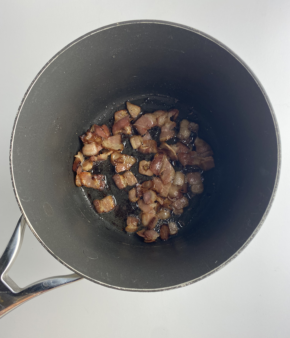 Sauteed bacon in a pot.