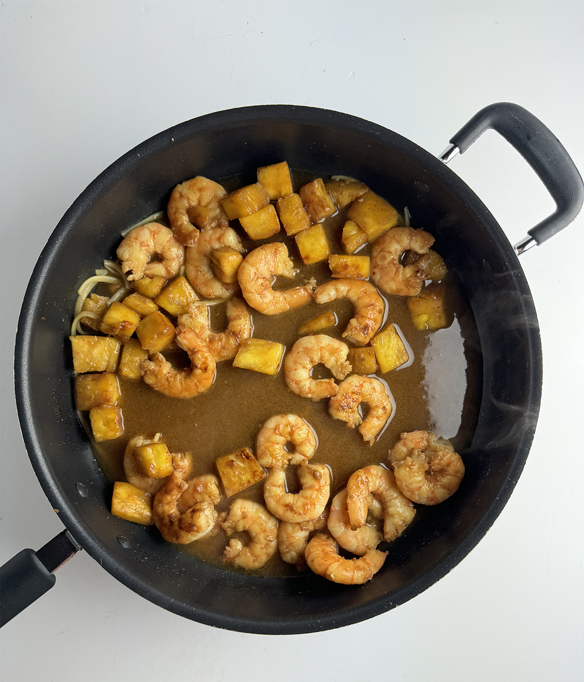 Shrimp and pineapple in a skillet.