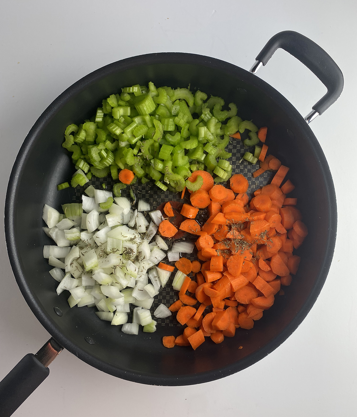 Skillet with uncooked vegetables.