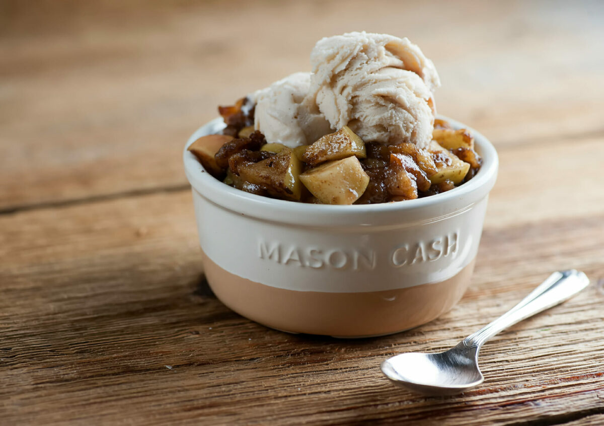 Apple Brown Betty in a bowl with ice cream.