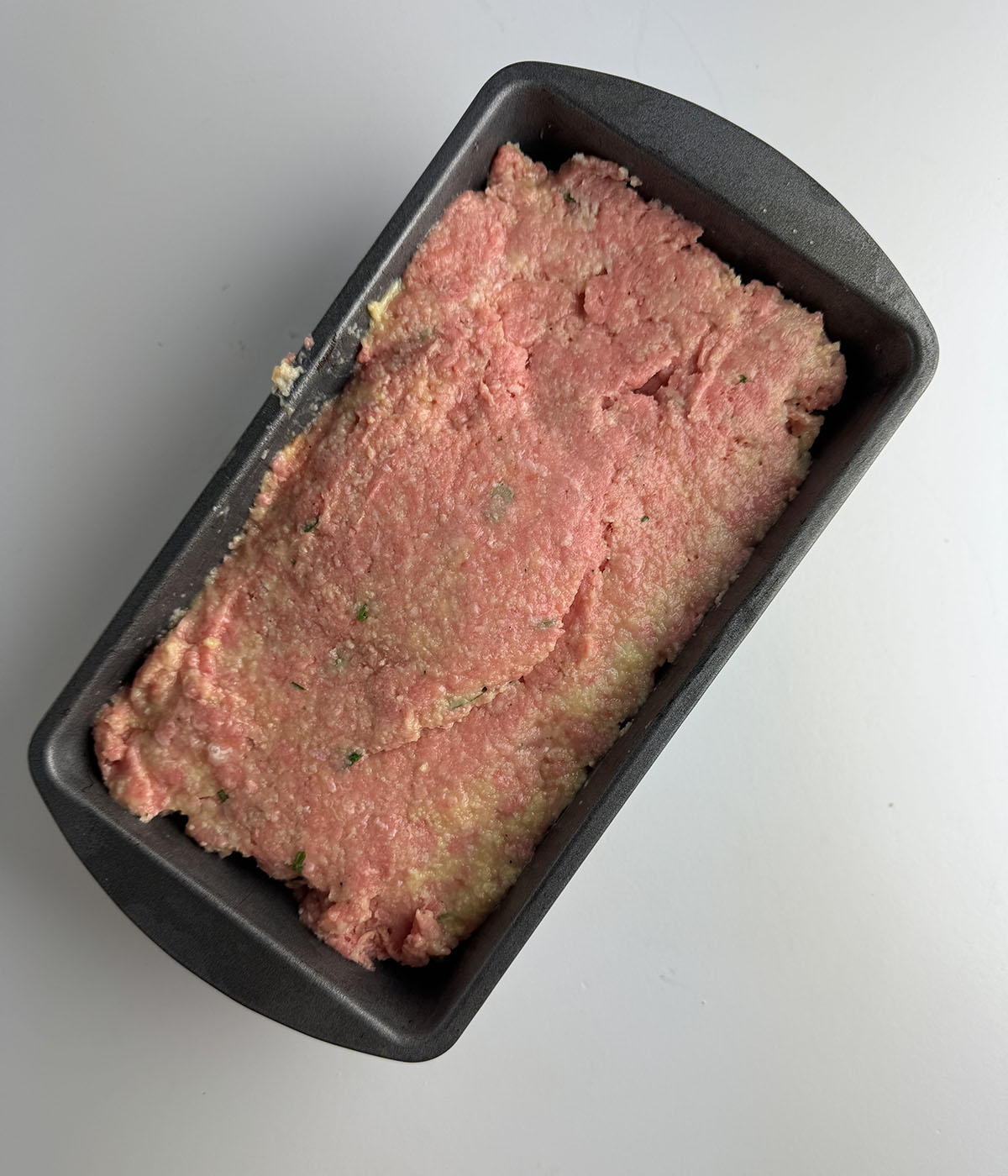 Meatloaf mixture in a loaf pan.