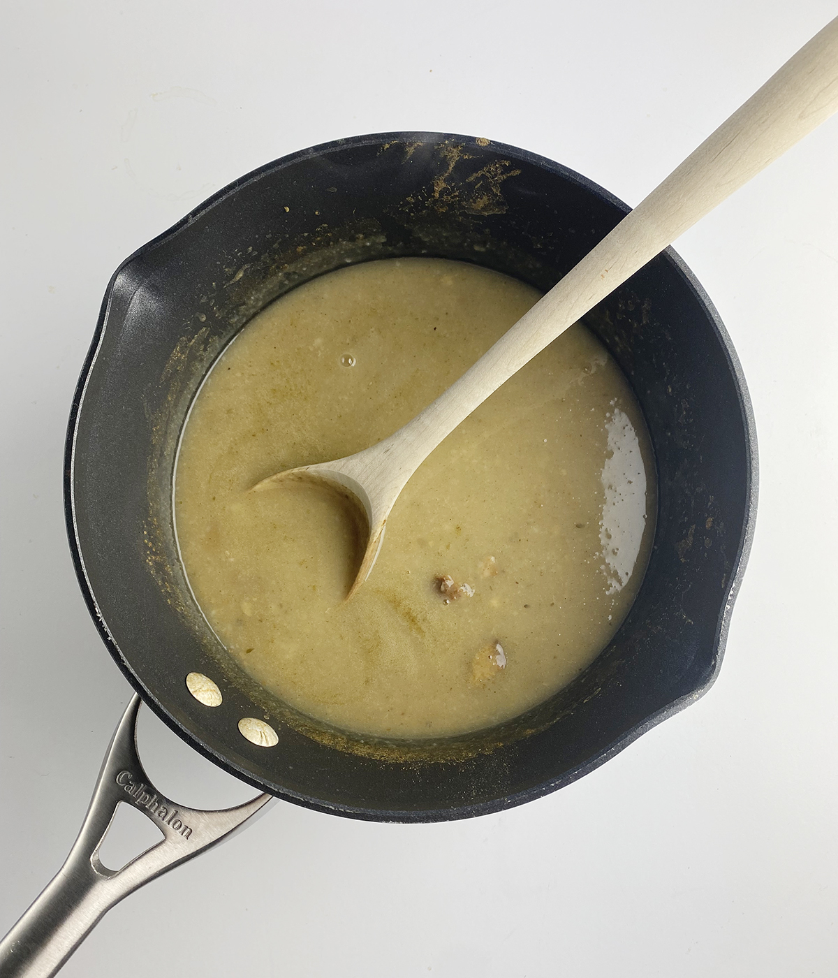 Thanksgiving leftovers soup broth with stuffing and mashed potatoes in a pot.