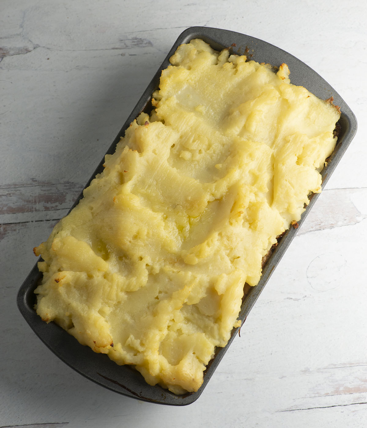 Baked mashed potato meatloaf in a pan.