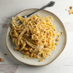 Brown butter walnut pasta on a plate with a fork.